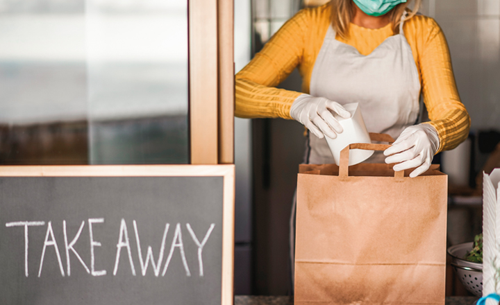 Woman putting food delivery in bag