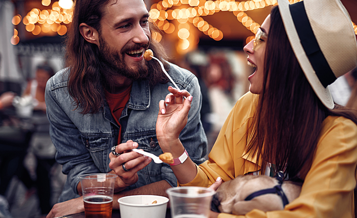 Couple eating outside with lights