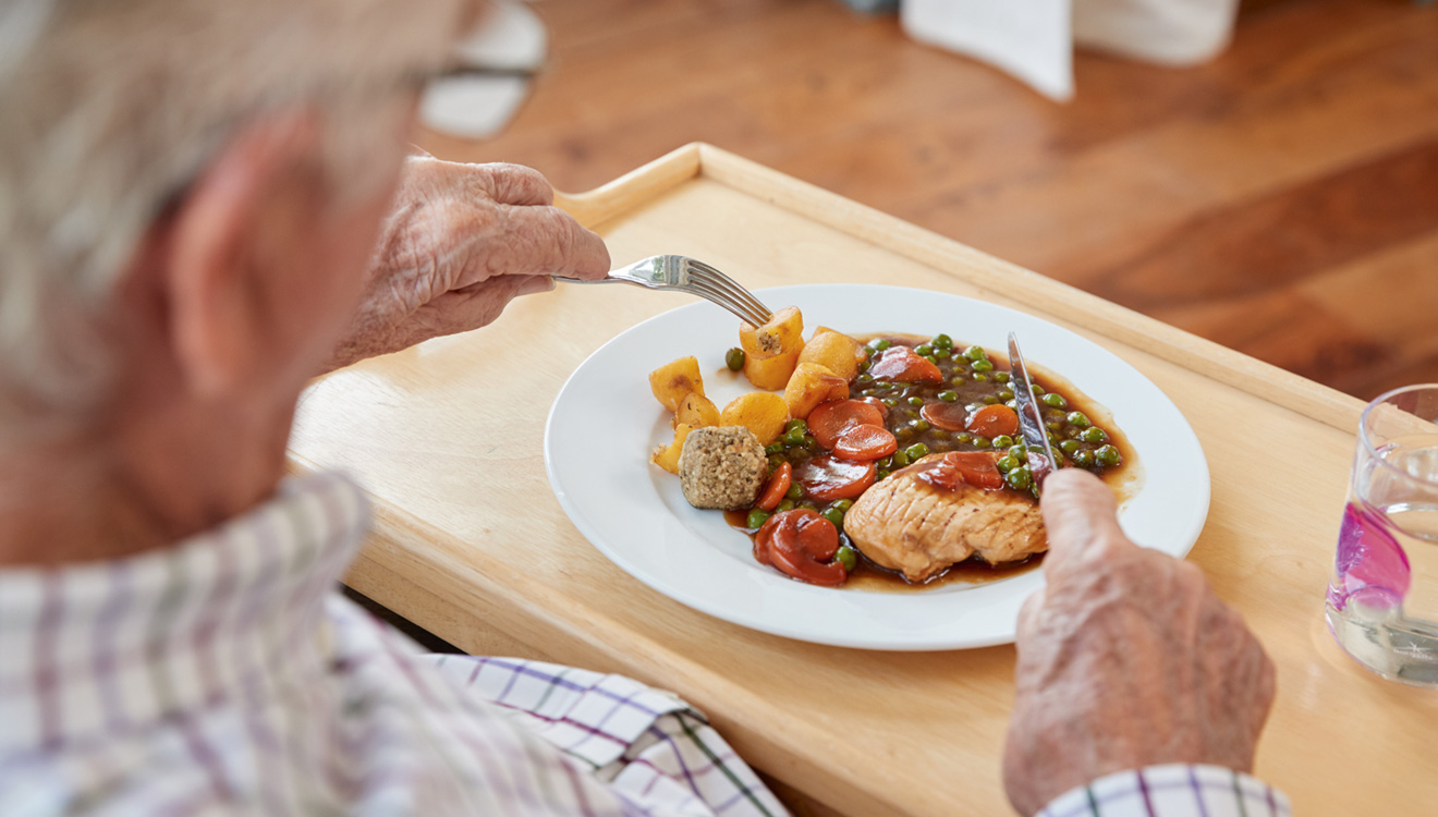 Elderly man eating meal