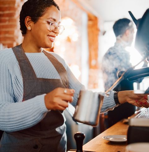 Woman making hot drink in cafe
