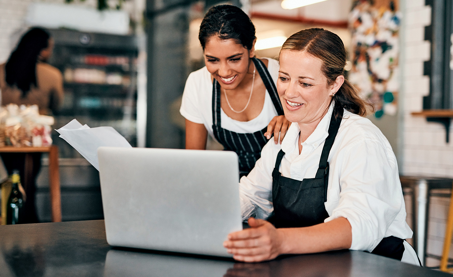 Two female hospitality workers looking at a laptop